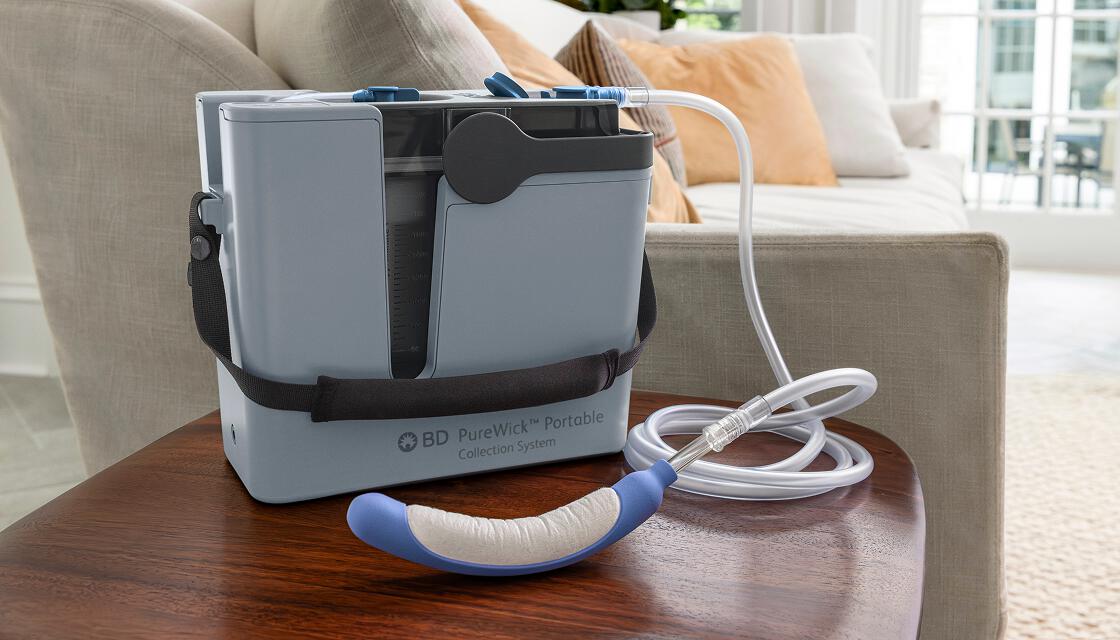 PureWick Portable Collection System with PureWick Flex Catheter attached on end table in living room