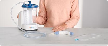 Nurse gestures towards counter with full glass of water, PureWick System, and PureWick Flex