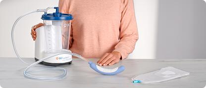 Person standing at counter with PureWick Urine Collection System, purple Flex catheter, and male external catheter