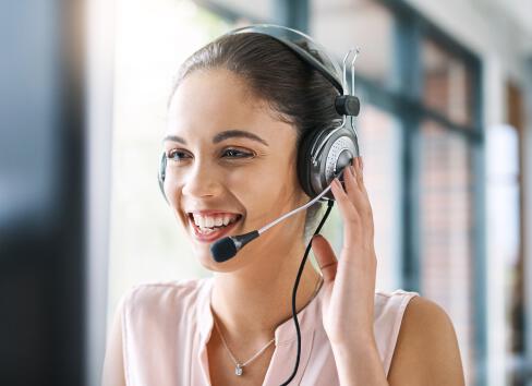 A smiling PureWick&trade; System Customer Service agent on the phone with a customer